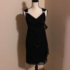 Black Dress, V Neck Bodice, Full Back Zipper, Sleeveless, Accented Front. Black Sleeveless Evening Dress For Prom Season, Black Sleeveless Evening Dress For Prom, Black Sleeveless Dress For Evening Prom, Fitted Sleeveless Dress For Evening Holiday, Fitted Sleeveless Dress For Holiday Evenings, Black Sleeveless Evening Dress, Sleeveless Evening Dress For Prom Season Dinner, Black Sleeveless Dress For Prom Party, Sleeveless Evening Dress For Dinner Parties