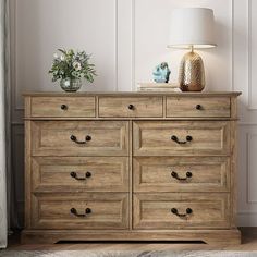 a wooden dresser sitting next to a lamp on top of a rug in a room