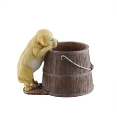 a small yellow dog sitting on top of a wooden barrel drinking water from it's faucet