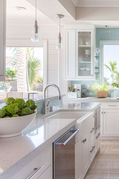 a large kitchen with white cabinets and marble counter tops, along with an island in the middle