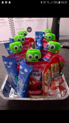 a bunch of toothpaste and gummy monster snacks in a tray on a table