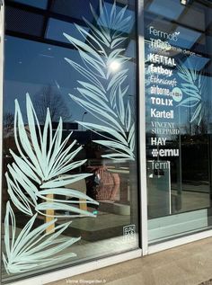 the window is decorated with frosted leaves and words on it's glass panels