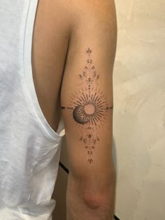 a man with a tattoo on his arm that has the sun and stars in it