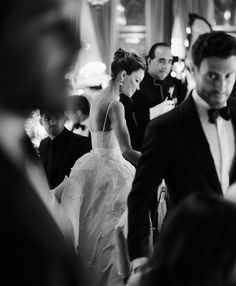 the bride and groom are walking down the aisle at their wedding reception in black and white