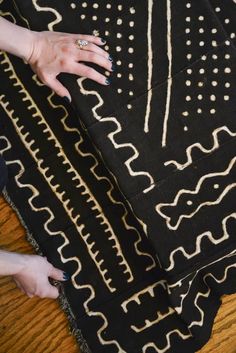 a woman's hands on top of a black and white rug