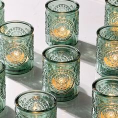 many green glass cups are lined up on the table