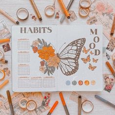 an open planner surrounded by various crafting supplies and scissors on top of a table