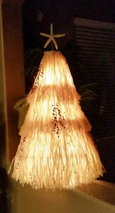 a lighted christmas tree sitting on top of a table