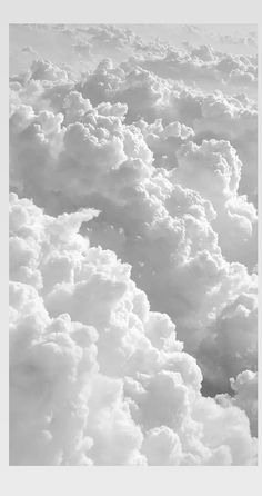 black and white photograph of clouds in the sky from an airplane window, looking down