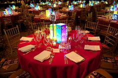 a red table topped with lots of tables covered in plates and glasses filled with wine