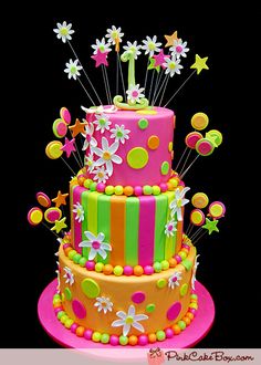 a birthday cake with flowers and stars on it's top is decorated in bright colors