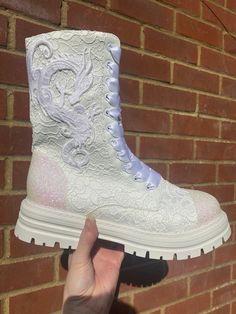 "All white dragon boots, Dragon lace boots, White lace boots, White bridal boots, Dragon ankle boots, Altenative wedding, Custom combats 👰🏻This pair of ALL WHITE combat style ankle boots features iridescent white glittered heels and toes with delicate white lace overlay, white applique dragons and ribbon laces. Zip up fastening. Perfect for an alternative wedding or everyday wear!  👰🏻This design can be glittered any colour you like and dragons come in multiple colours. Please message to discuss a custom order.  👰🏻As each pair is handmade no two will ever be exactly the same.  ✨I can create glitter shoes in any colour on most styles of shoe. I even custom mix glitter colours and can match them to fabric/dresses etc. Glittered undersoles and personalisation can also be added. Initials, Dragon Boots, White Lace Boots, Ribbon Laces, Bridal Boots, Combat Style, Iridescent White, Heel Grips, Boots White, White Dragon