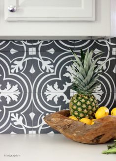 pineapple, lemons and asparagus in a wooden bowl on a kitchen counter