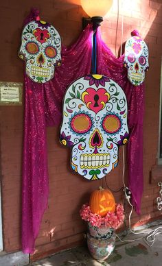 the day of the dead decorations are on display in front of a brick wall with pink drapes