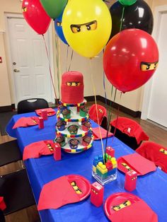 the table is set up for a lego movie themed birthday party with balloons and decorations