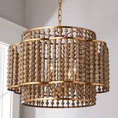 a wooden beaded chandelier hanging from a ceiling in a room with white walls