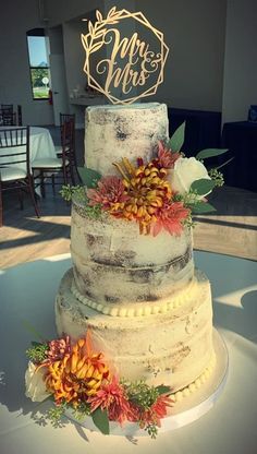 a three tiered cake with flowers on top