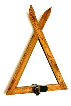 a wooden triangle shaped object with two crossed blades on the top and one pointed at the bottom