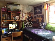 a bed room with a neatly made bed next to a desk and shelves filled with books