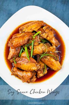 chicken wings with sauce in a white bowl on a blue tablecloth and the title says soy sauce chicken wings