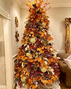 a decorated christmas tree in the corner of a living room with an orange and yellow theme