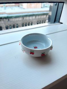 a white bowl sitting on top of a window sill