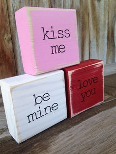 three blocks with words painted on them that say kiss me and be mine