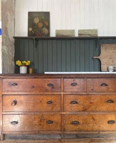 an old wooden dresser with flowers on top