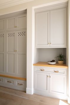 an empty kitchen with white cabinets and wood flooring