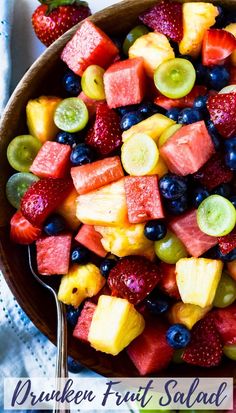 a bowl filled with fresh fruit salad on top of a table