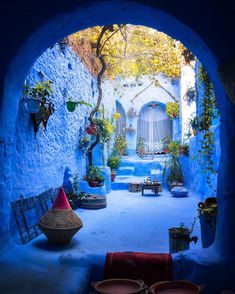 a woman sitting on a bench in the middle of an alleyway with potted plants