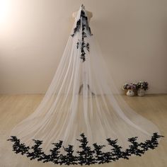 a wedding veil with black flowers on it