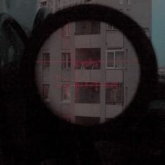 a view through a magnifying glass looking at an apartment building in the distance