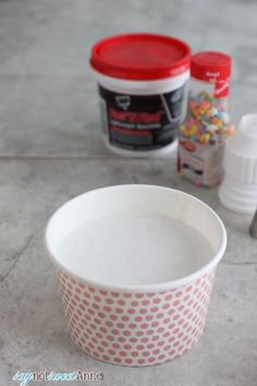 two empty cups sitting on top of a table next to some confection containers