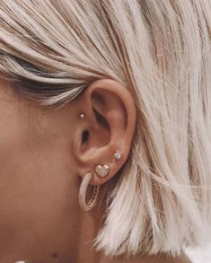 a woman with blonde hair wearing ear piercings