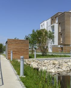 there are two buildings on the other side of the water and one building is made out of wood