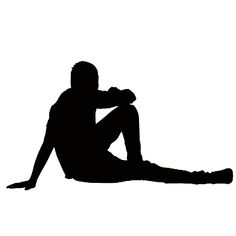 the silhouette of a man sitting on the ground with his legs crossed, looking down