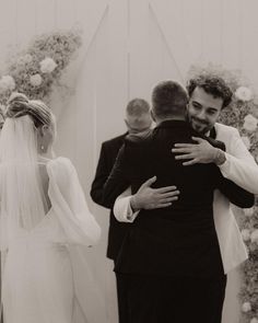 a bride and groom hug each other as they walk down the aisle