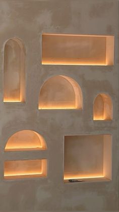 an assortment of shelves lit up with lights in the shape of arches and niches