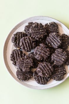 a white plate topped with chocolate cookies on top of a table