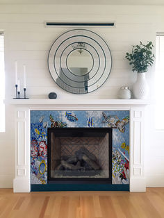 a living room with a fire place and mirror on the wall above it's mantle