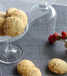 some cookies are sitting on a table next to a glass vase with flowers in it