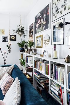 a living room filled with lots of books and plants