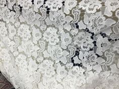 an image of white lace with flowers on it