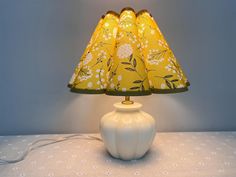 a white lamp with a yellow shade on it