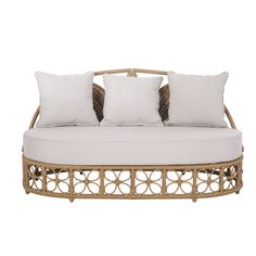 a wicker daybed with four pillows on it