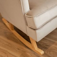 a white rocking chair sitting on top of a hard wood floor