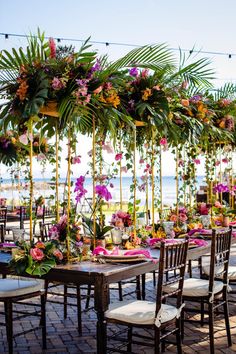 an outdoor dining area decorated with flowers and greenery