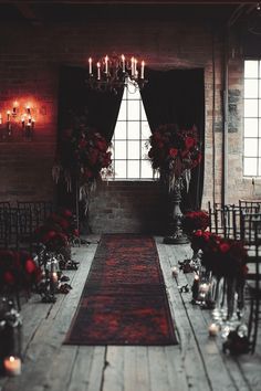 the aisle is decorated with red roses and candles