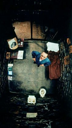 a man standing in the middle of a room with papers on the floor and walls